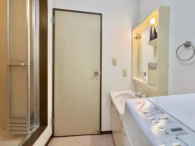 a bathroom with a door leading to a sink at \u30a8\u30de\u30fc\u30ec\u6771\u5c0f\u5ca9101 \u5c0f\u5ca9\u99c5\u5f92\u6b695\u5206 \u6700\u59277\u540d \u548c\u5ba4\u7573 in Tokyo
