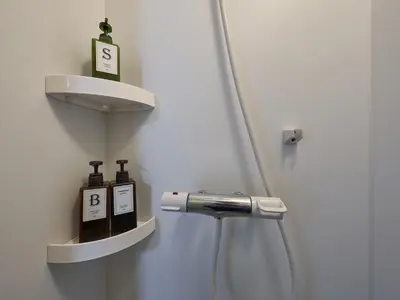 a bathroom with a shower with two soap bottles at Yadoya Asakusa Kokeshian in Tokyo