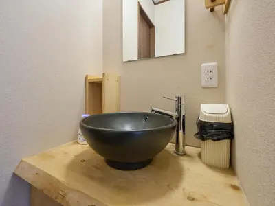 a bathroom with a black bowl sink on a wooden counter at Yadoya Asakusa Kokeshian in Tokyo