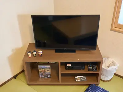 a flat screen tv on a wooden entertainment center at Yadoya Asakusa Kokeshian in Tokyo