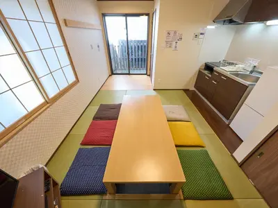 a communal table in a kitchen with colorful mats on the floor at Yadoya Asakusa Kokeshian in Tokyo