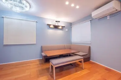 a dining room with a table and a couch and a fan at Hatagaya Honmachi house \u6da9\u8c37-SY0488 in Tokyo