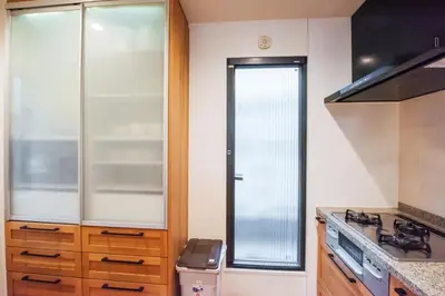 a kitchen with a stove and a glass door at Hatagaya Honmachi house \u6da9\u8c37-SY0488 in Tokyo