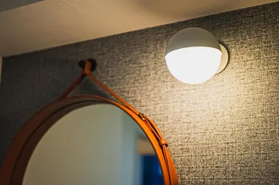 a lamp with a mirror and a light on a wall at Svalley YIG stay 401 in Tokyo