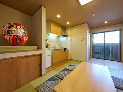 a kitchen with a table and a large vase on the wall at Yadoya Asakusa Darumaan in Tokyo