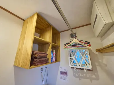 a wooden cabinet hanging on a wall with towels at Yadoya Asakusa Darumaan in Tokyo