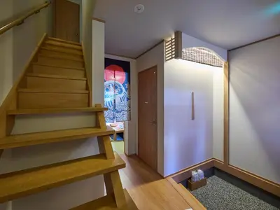 a hallway with wooden stairs and a door at Yadoya Asakusa Darumaan in Tokyo