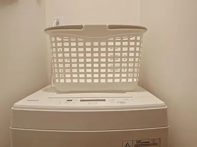 a laundry basket sitting on top of a washing machine at Grace Tokyo Yazen located at Ikebukuro Station Direct access to Shinjuku and Shibuya Comfortable and convenient for travel in Tokyo