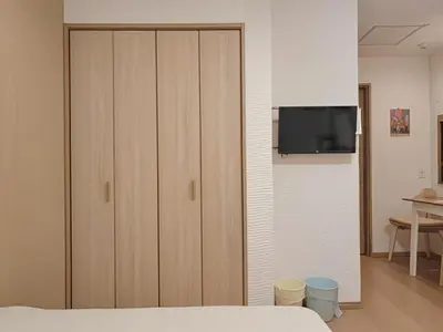 a bedroom with a closet with a tv on a wall at Grace Tokyo Yazen located at Ikebukuro Station Direct access to Shinjuku and Shibuya Comfortable and convenient for travel in Tokyo