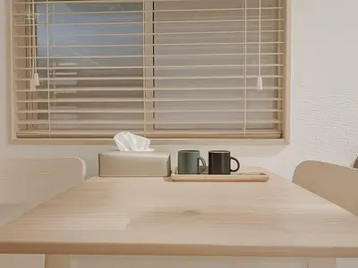 two coffee mugs on a wooden table in front of a window at Grace Tokyo Yazen located at Ikebukuro Station Direct access to Shinjuku and Shibuya Comfortable and convenient for travel in Tokyo