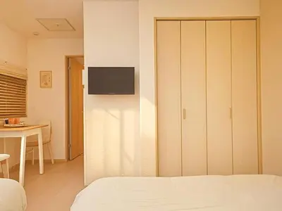 a bedroom with a bed and a tv on a wall at Grace Tokyo Yazen located at Ikebukuro Station Direct access to Shinjuku and Shibuya Comfortable and convenient for travel in Tokyo