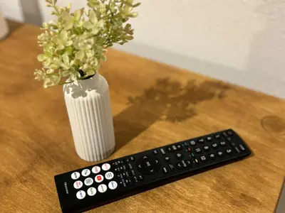 a remote control and a vase of flowers on a table at Kagisippo yushima in Tokyo
