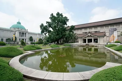 a large building with a pond in front of it at Kagisippo yushima in Tokyo