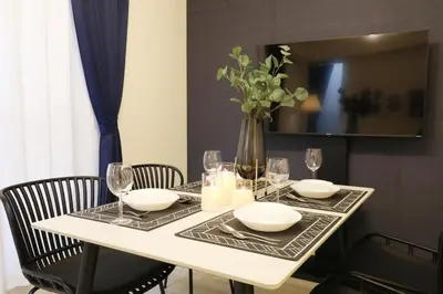 a white table with chairs and a vase with flowers at Espada KAMEARI 103 in Tokyo