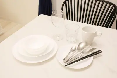a white table with plates and silverware on it at Espada KAMEARI 103 in Tokyo