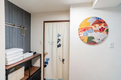 a bathroom with a shower curtain and a plate on the wall at 203 Room, a 6-minute walk from Tokyo Koiwa Station Direct connected to Shinjuku and Akihabara Stations Comfortable one-bedroom apartment with separate wet and dry areas in Tokyo