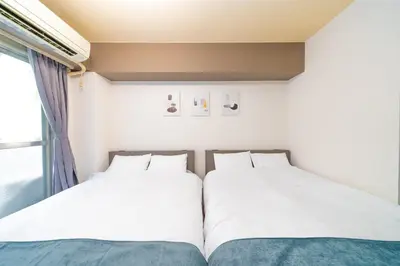 two beds sitting next to each other in a room at Hotel SHINJYUKU in Tokyo