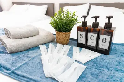 a bed with a blue rug with three bottles of essential oils at Hotel SHINJYUKU in Tokyo