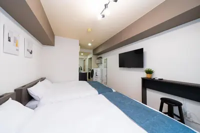 a bedroom with a bed and a tv on the wall at Hotel SHINJYUKU in Tokyo