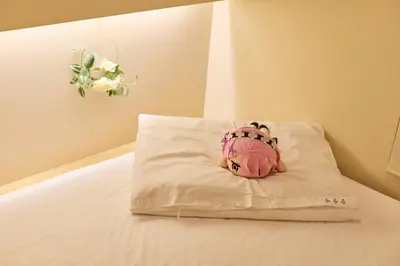 a stuffed animal is sitting on a pillow on a bed at Hotel \u30d5\u30eb\u30fc\u30eb301 in Tokyo