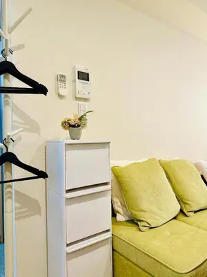 a living room with a green couch and a shelf at jlb\u30b0\u30e9\u30f3\u30a8\u30af\u30ea\u30e5\u521d\u53f0 101 in Tokyo