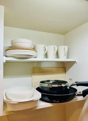 a kitchen shelf with plates and bowls and a pan at jlb\u30b0\u30e9\u30f3\u30a8\u30af\u30ea\u30e5\u521d\u53f0 101 in Tokyo