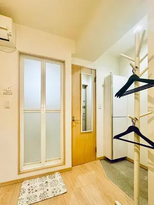 a room with a refrigerator and a door with shelves at jlb\u30b0\u30e9\u30f3\u30a8\u30af\u30ea\u30e5\u521d\u53f0 101 in Tokyo