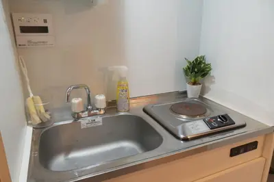 a kitchen with a sink and a stove at Raiya Stay at Machiya in Tokyo
