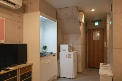 a kitchen with a refrigerator and a tv in a room at Raiya Stay at Machiya in Tokyo