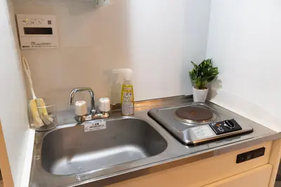 a kitchen counter with a sink and a stove at Raiya Stay at Machiya in Tokyo