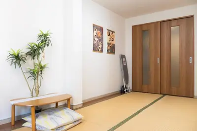 a room with a door and a table and a plant at Raiya Stay at Machiya in Tokyo
