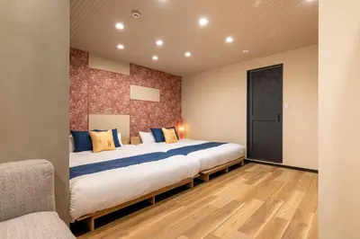 a bedroom with a large bed with blue and yellow pillows at Js Asakusa 6-minute walk from Asakusa Station in Tokyo