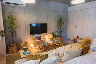 a living room with a couch and a tv at Omotenashi HOTEL FamilyStay in Tokyo