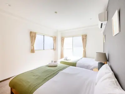 two beds in a room with two windows at Hotel Shibamata Tokyo in Tokyo