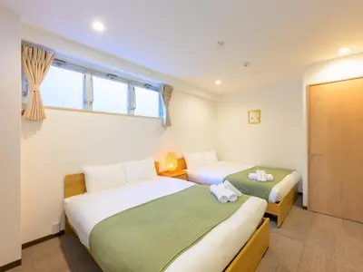 a bedroom with two beds and a window at Hotel Shibamata Tokyo in Tokyo