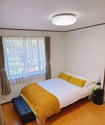 a bedroom with a bed with a yellow blanket and a window at Maenochō, Itabashi City-2LDK 王house IT0489 in Tokyo