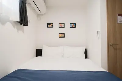 a bed in a room with pictures on the wall at 3BRBig House for 7 2 Stops Direct to Tokyo Skytree EntireHome in Sumida in Tokyo