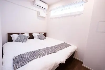 a bedroom with two beds and a window at Sunbright Asakusa 101 in Tokyo