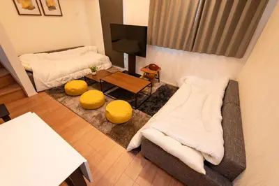 a living room with a couch and a tv at Deload Hotel \u6771\u4eac\u3059\u307f\u3060 in Tokyo