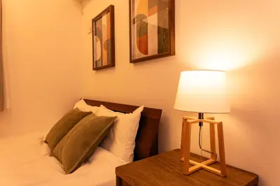 a bedroom with a bed and a table with a lamp at Deload Hotel \u6771\u4eac\u3059\u307f\u3060 in Tokyo