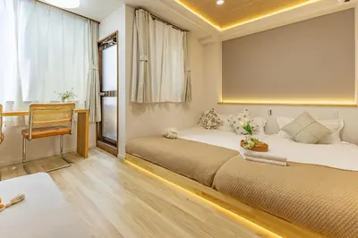 a bedroom with two beds and a chair in it at Direct to Shinjuku Higashi-Nakano New APT family First Choice in Tokyo