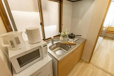 a small kitchen with a sink and a microwave at Direct to Shinjuku Higashi-Nakano New APT family First Choice in Tokyo