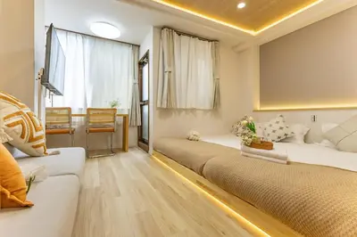 a hotel room with two beds and a couch at Direct to Shinjuku Higashi-Nakano New APT family First Choice in Tokyo