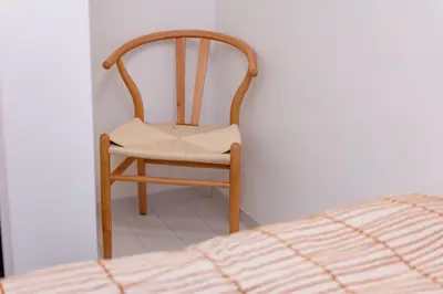 a wooden chair sitting in a corner next to a bed at VicoloHouse\u5343\u4f4f\u5927\u6a4b,Family Friendly New House,Near Skytree,12 Guests in Tokyo