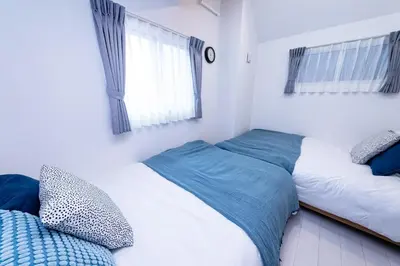 two twin beds in a bedroom with a window at VicoloHouse\u5343\u4f4f\u5927\u6a4b,Family Friendly New House,Near Skytree,12 Guests in Tokyo