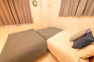 a bed with two pillows on it in a bedroom at VicoloHouse\u5343\u4f4f\u5927\u6a4b,Family Friendly New House,Near Skytree,12 Guests in Tokyo