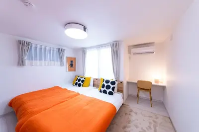a bedroom with an orange bed and a window at VicoloHouse\u5343\u4f4f\u5927\u6a4b,Family Friendly New House,Near Skytree,12 Guests in Tokyo