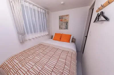 a small bedroom with an orange pillow on a bed at VicoloHouse\u5343\u4f4f\u5927\u6a4b,Family Friendly New House,Near Skytree,12 Guests in Tokyo