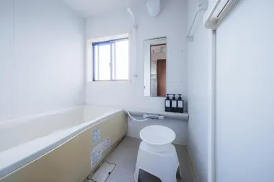 a white bathroom with a toilet and a window at KR Fit Stay Kami-Itabashi in Tokyo
