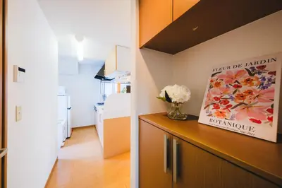 a kitchen with a vase of flowers on a cabinet at KR Fit Stay Kami-Itabashi in Tokyo